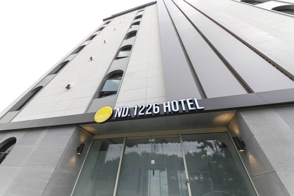 The exterior of the ND.1226 Hotel with a modern design, featuring a prominent entrance with glass doors and a clear view of the surrounding area. - ND.1226 Hotel (Busan)