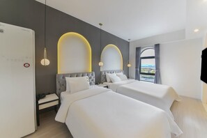 A modern hotel room with two beds, a desk, and a view of the city. - ND.1226 Hotel (Busan)