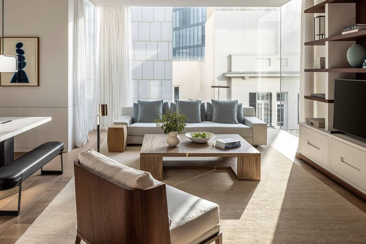 Una sala moderna con sofá, mesa de centro y comedor con banco y mesa.