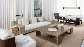 A modern living room with a sofa, coffee table, and dining area.