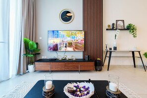 Appartement Deluxe | Coin séjour | TV connectée de 65 pouces avec chaînes par câble