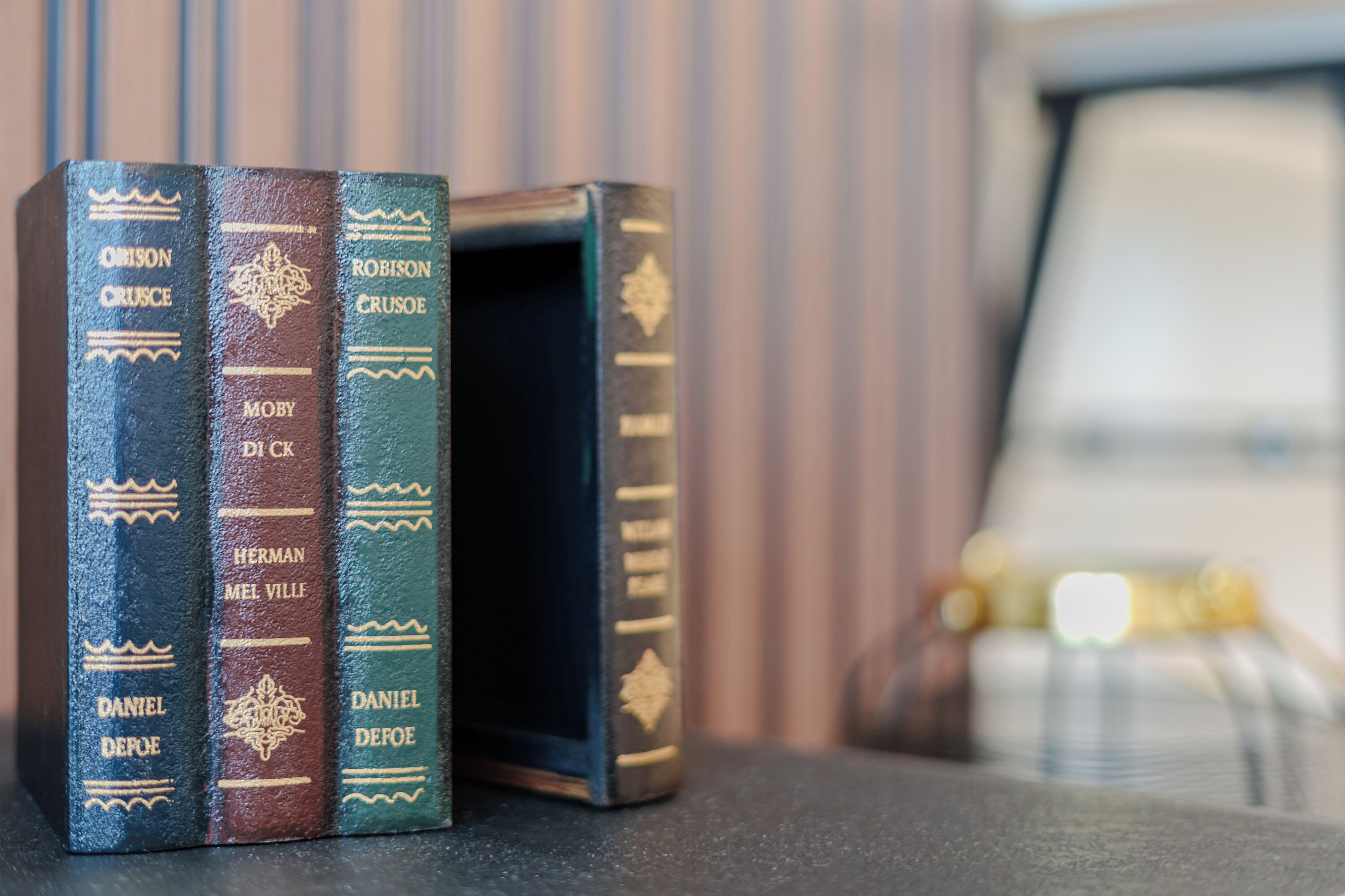 Drie boeken op een rij, met de ruggen naar voren gericht, elk met een andere auteursnaam.