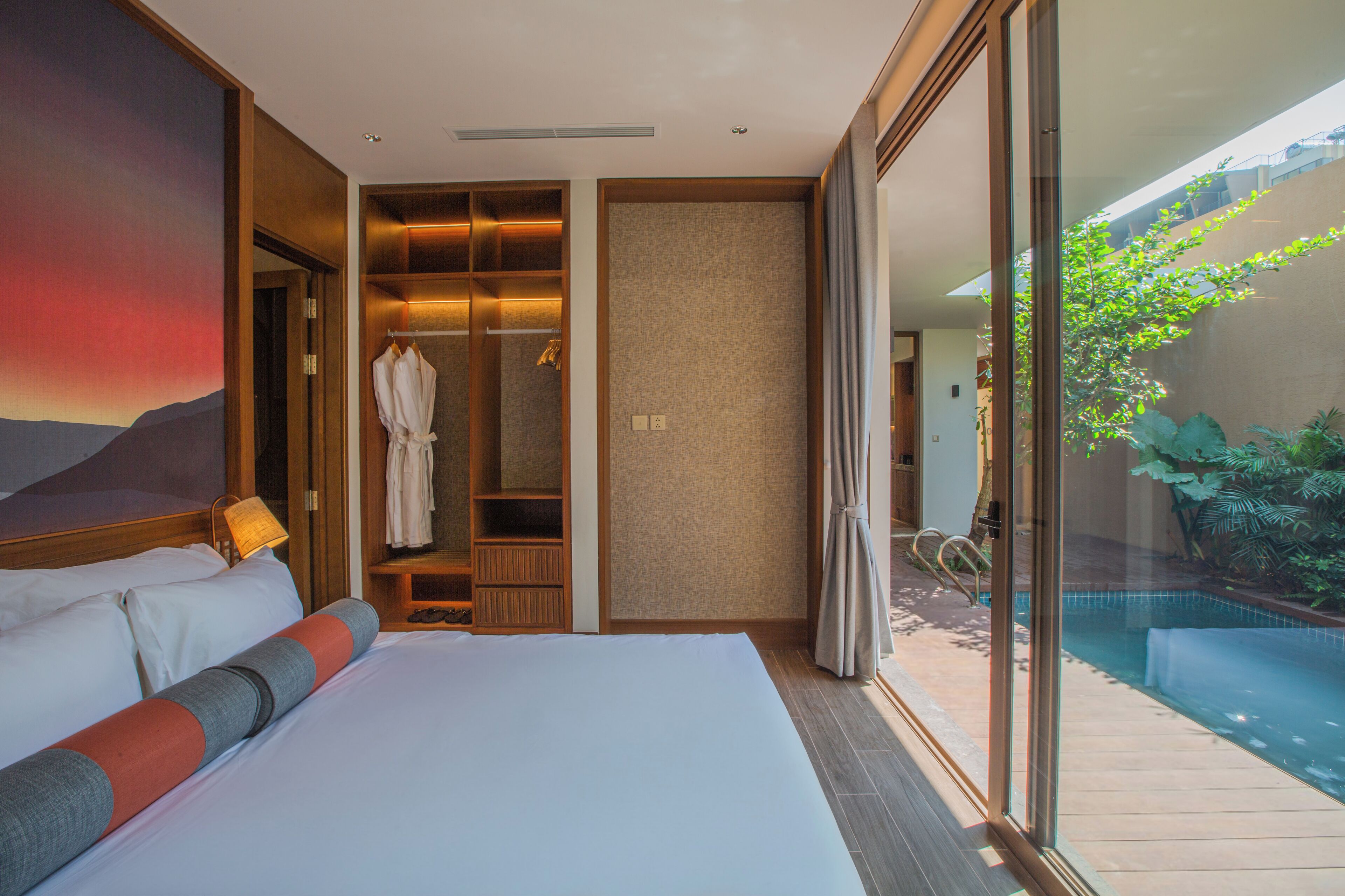 Un dormitorio con una cama grande, un vestidor y vistas a una piscina.