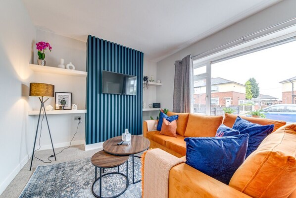 A modern living room with a sofa, coffee table, and TV. - Modern 3 bed, home from home with free parking (Barnsley)