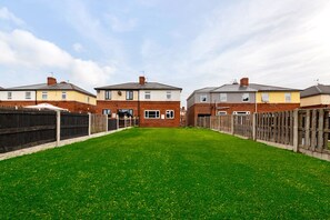 A row of terraced houses with a grassy front yard. - Modern 3 bed, home from home with free parking (Barnsley)