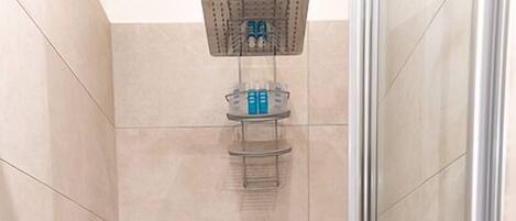 A shower area with a handheld showerhead and a wall-mounted control panel.