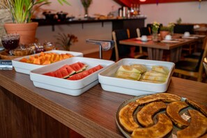 A buffet with various food items including watermelon, cheese, and banana slices. - Wanderlust Experience Hotel, BW Signature (Campos do Jordão)