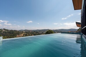 Una piscina infinita con vistas a un paisaje montañoso.