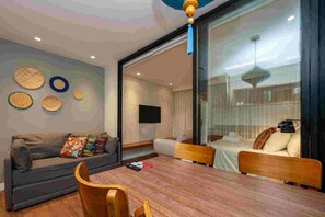 A modern living room with a sofa, a dining table, and a TV. - Wanderlust Experience Hotel, BW Signature (Campos do Jordão)