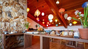 A breakfast buffet with a variety of food items and a stone wall backdrop. - Wanderlust Experience Hotel, BW Signature (Campos do Jordão)