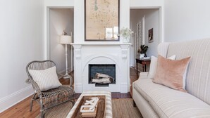 Ein Wohnzimmer mit Kamin, einer Karte an der Wand, einem Sofa, einem Sessel und einem Couchtisch.