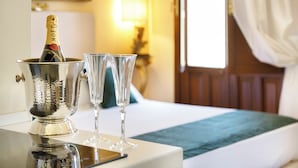 A champagne bottle in a silver bucket, two empty glasses, and a smartphone on a table in a hotel room. - Saint George's House Apartments & SPA (Pachino)