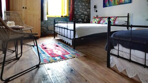 A bedroom with a wooden ceiling, a bed, a chair, a wardrobe, a window, and a painting. - Ilios Gokceada (Gökçeada)