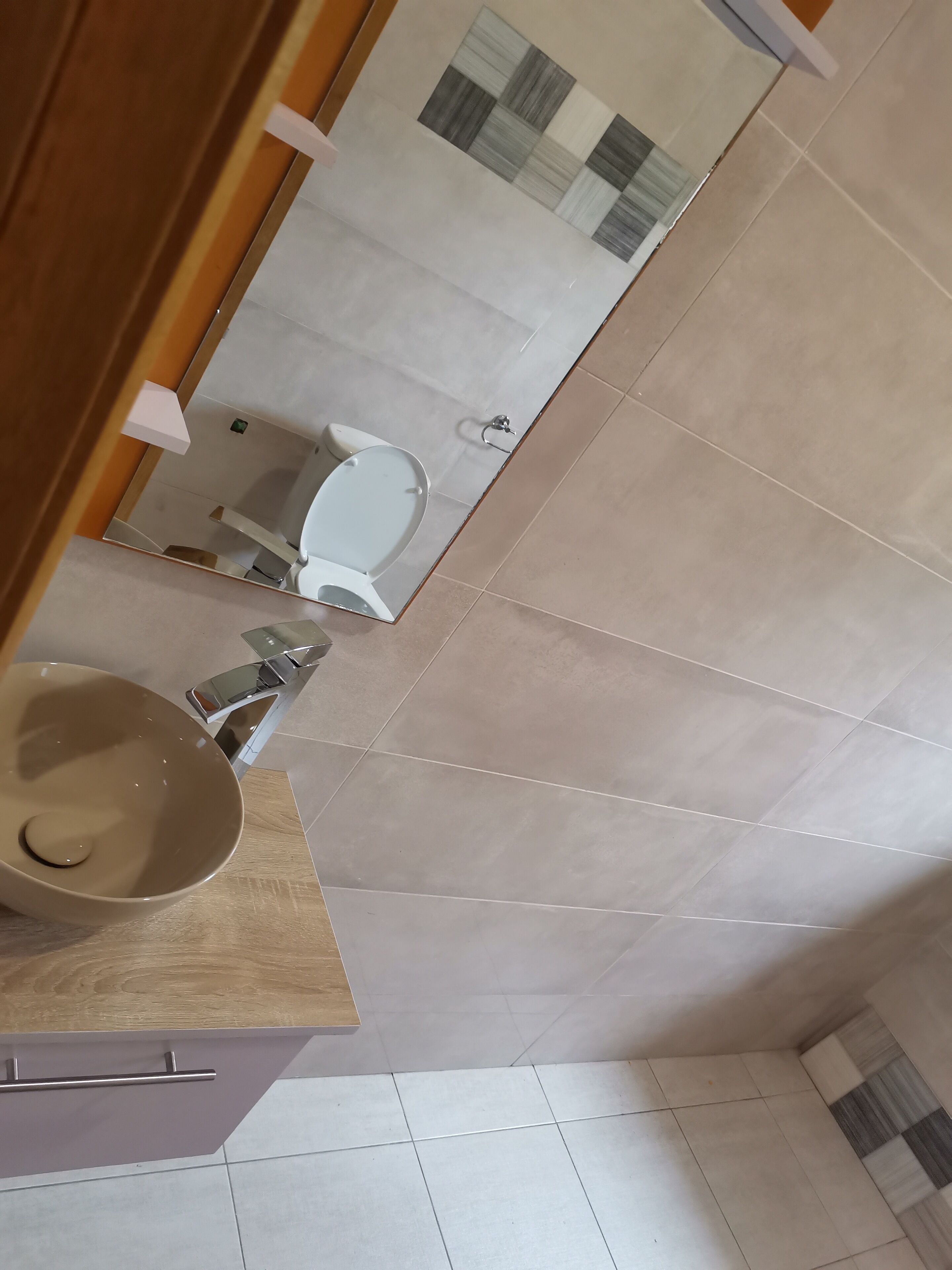A bathroom with a sink, mirror, and toilet.