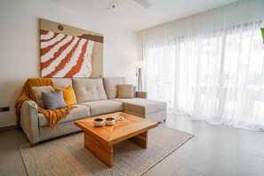 Una sala moderna con un sofá, una mesa de centro y un cuadro abstracto grande.