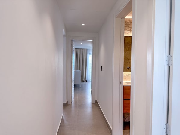 Un pasillo con una puerta que da a un baño.