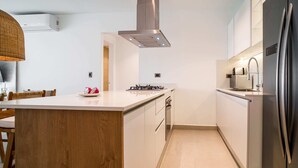 A modern kitchen with a central island, stainless steel appliances, and a clean, minimalist design. - Luxury 3 bedroom Apartment at the beach (Punta Cana)