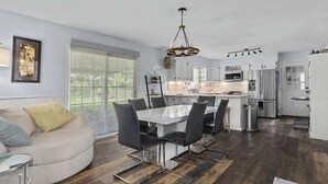 A modern kitchen with a central island, white cabinetry, and stainless steel appliances. - Calling All Gamers_Sleeps 10_Near MCI_Fun for All (Platte City)