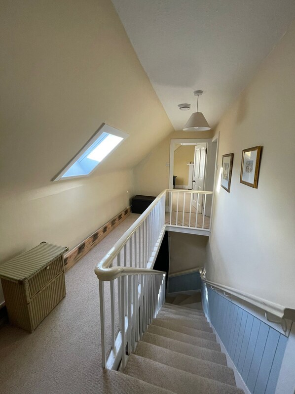 A staircase with a white railing, a skylight, and a small bench. - The Fiddichside Inn (Aberlour)