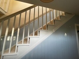 Una escalera con barandillas blancas y una pared azul.
