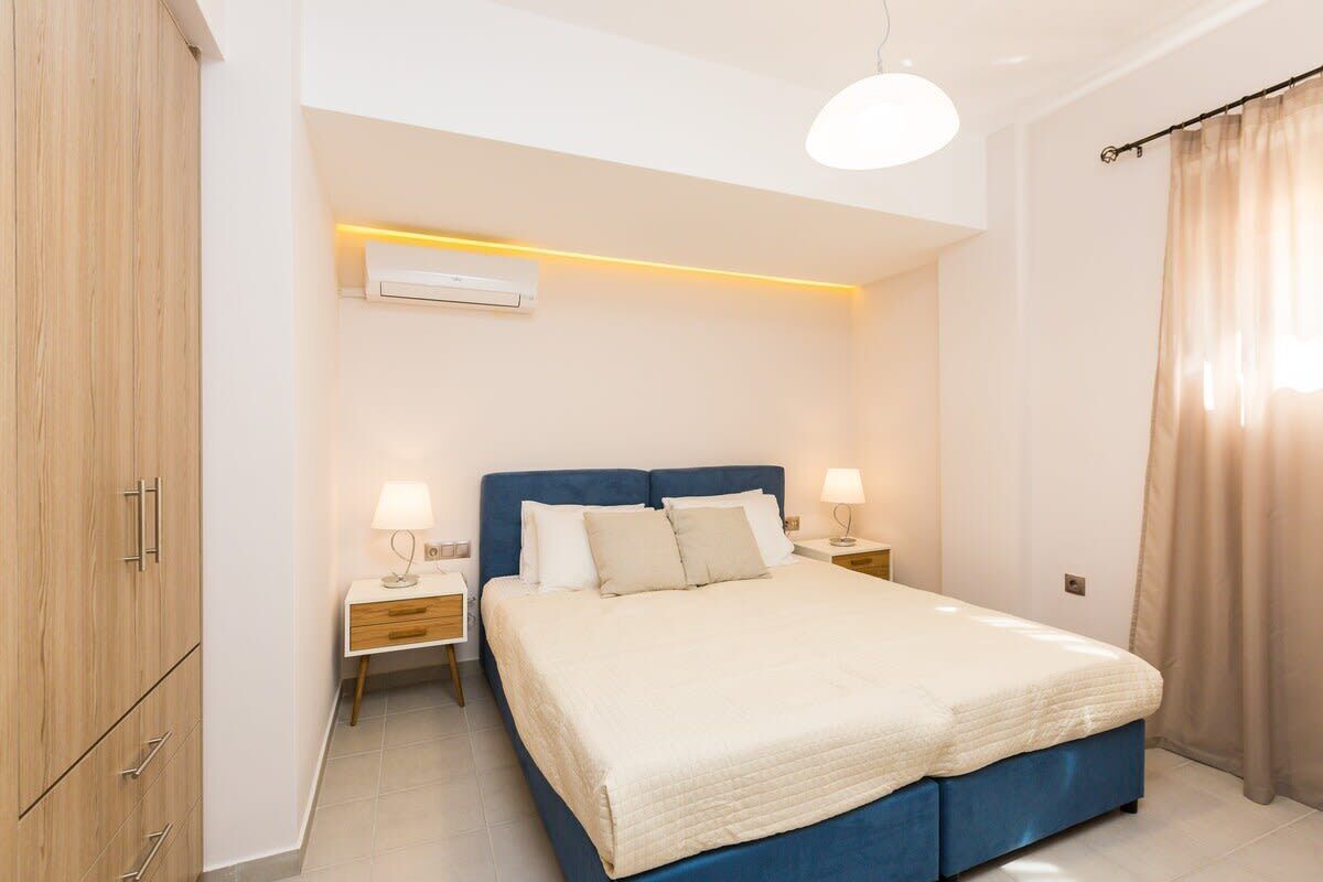 A bedroom with a bed, bedside tables, a wardrobe, and a ceiling light.