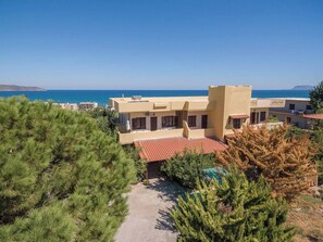 A coastal hotel with multiple buildings, a clear view of the sea, and a pathway leading to the entrance. - Romantic Corner - Anoula Osase Sea View Maisonette (Stalos)
