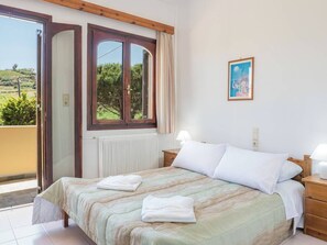 A bedroom with a bed, a window, a radiator, and a picture on the wall. - Romantic Corner - Penelope Sea View Maisonette (Stalos)