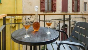 A round table with two glasses and a bottle on a balcony. - Casa Sorvolou Boutique House (Chania)