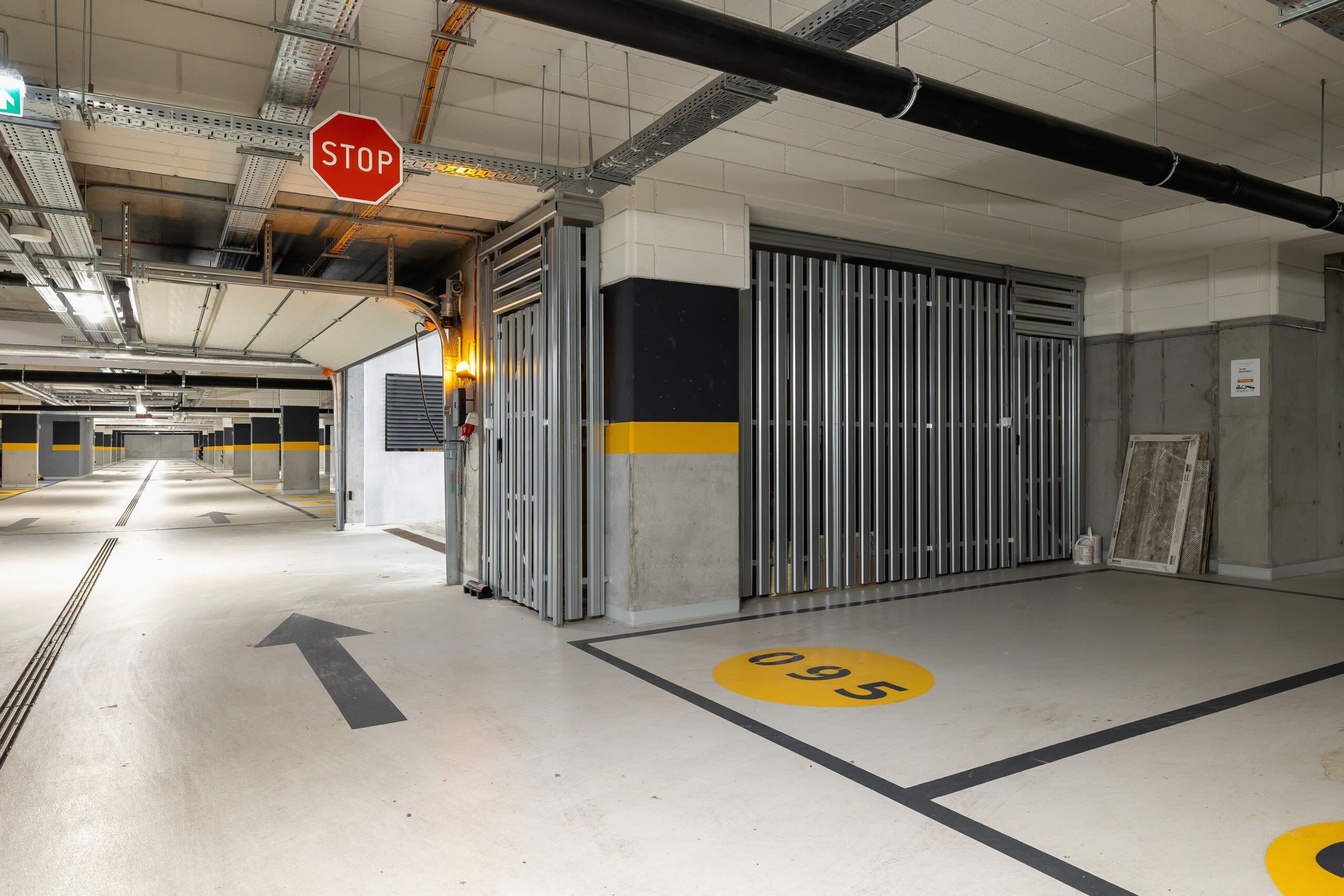 A parking garage with a stop sign, directional arrows, and a garage number.
