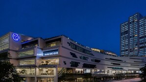 A multi-story building with a prominent 'Coca-Cola' sign, a 'Martha's Roost' food hall, and a modern architectural design. - Brittany Hotel BGC (Taguig)