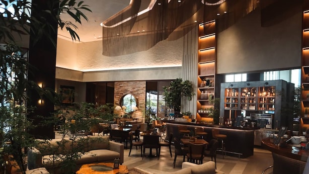 A modern lounge area with sofas, tables, and a bar. - Brittany Hotel BGC (Taguig)
