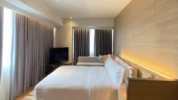 Una habitación de hotel moderna con una cama grande, un televisor de pantalla plana y una pared de acento de madera.