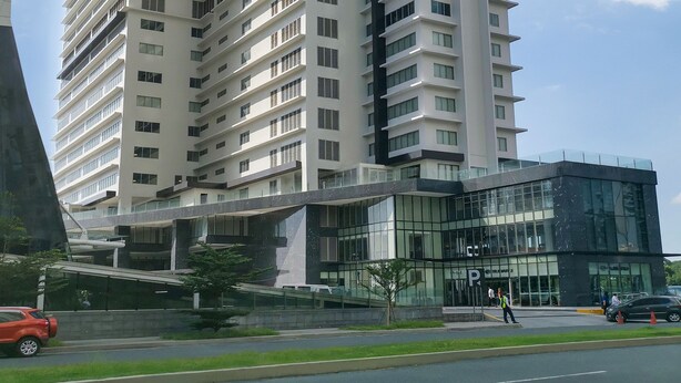 Un edificio moderno y alto, un rascacielos con muchas plantas y fachada de vidrio.
