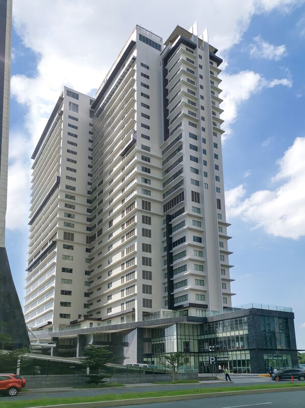 A tall, modern high-rise building with multiple floors and a glass facade. - Brittany Hotel BGC (Taguig)