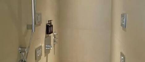 A modern shower with a handheld showerhead, a handheld faucet, and a built-in seat.