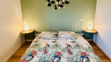 Un dormitorio con cama, dos lámparas de noche, una lámpara de techo geométrica y un adorno en la pared.