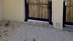 A beige building with a black metal gate, a small window, and a wall-mounted device. - Le Grand *** - 3 bedrooms, all new & all inclusive (Montauban)