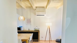 A modern kitchen with wooden cabinets, a dining table with chairs, and a hanging pendant light. - Le Grand *** - 3 bedrooms, all new & all inclusive (Montauban)