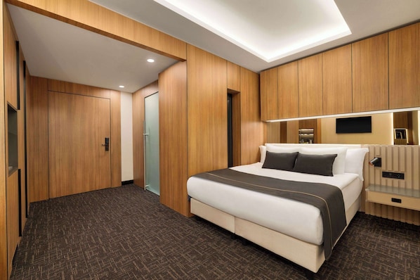 A modern hotel room with a large bed, wooden paneling, a flat-screen TV, and a bedside table. - FT Lotus Thermal Hotel&Spa, Trademark Collection By Wyndham (Menemen)