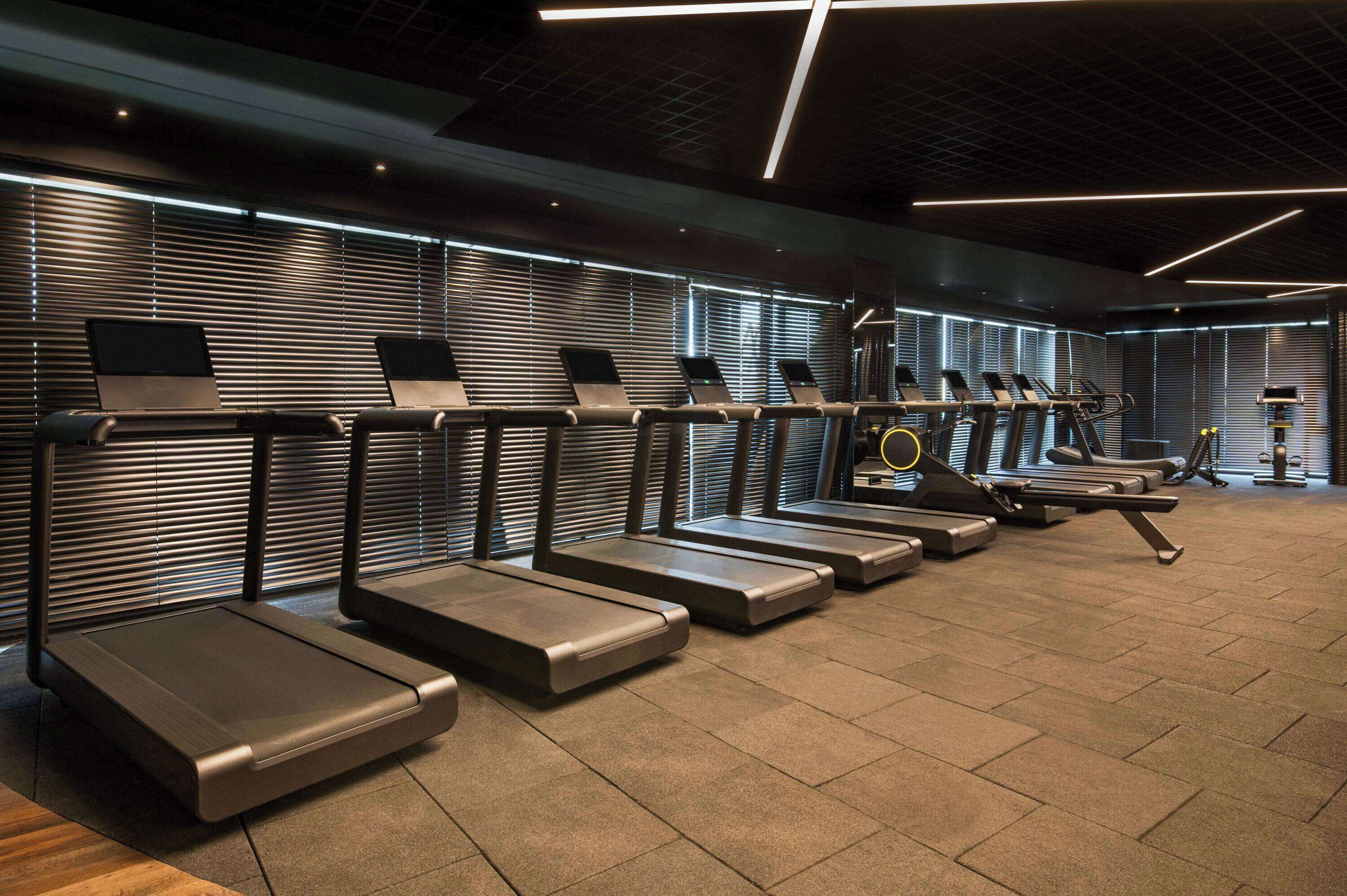 A modern gym with multiple treadmills and exercise equipment.