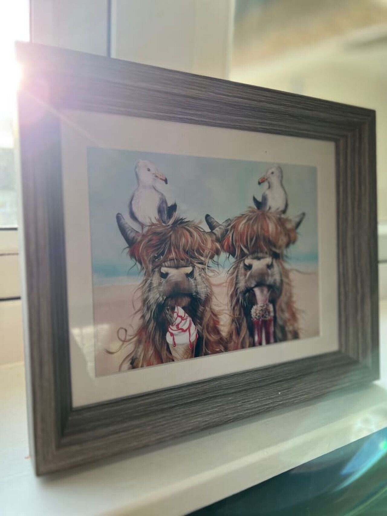 A framed artwork of three horses with a seagull perched on one.
