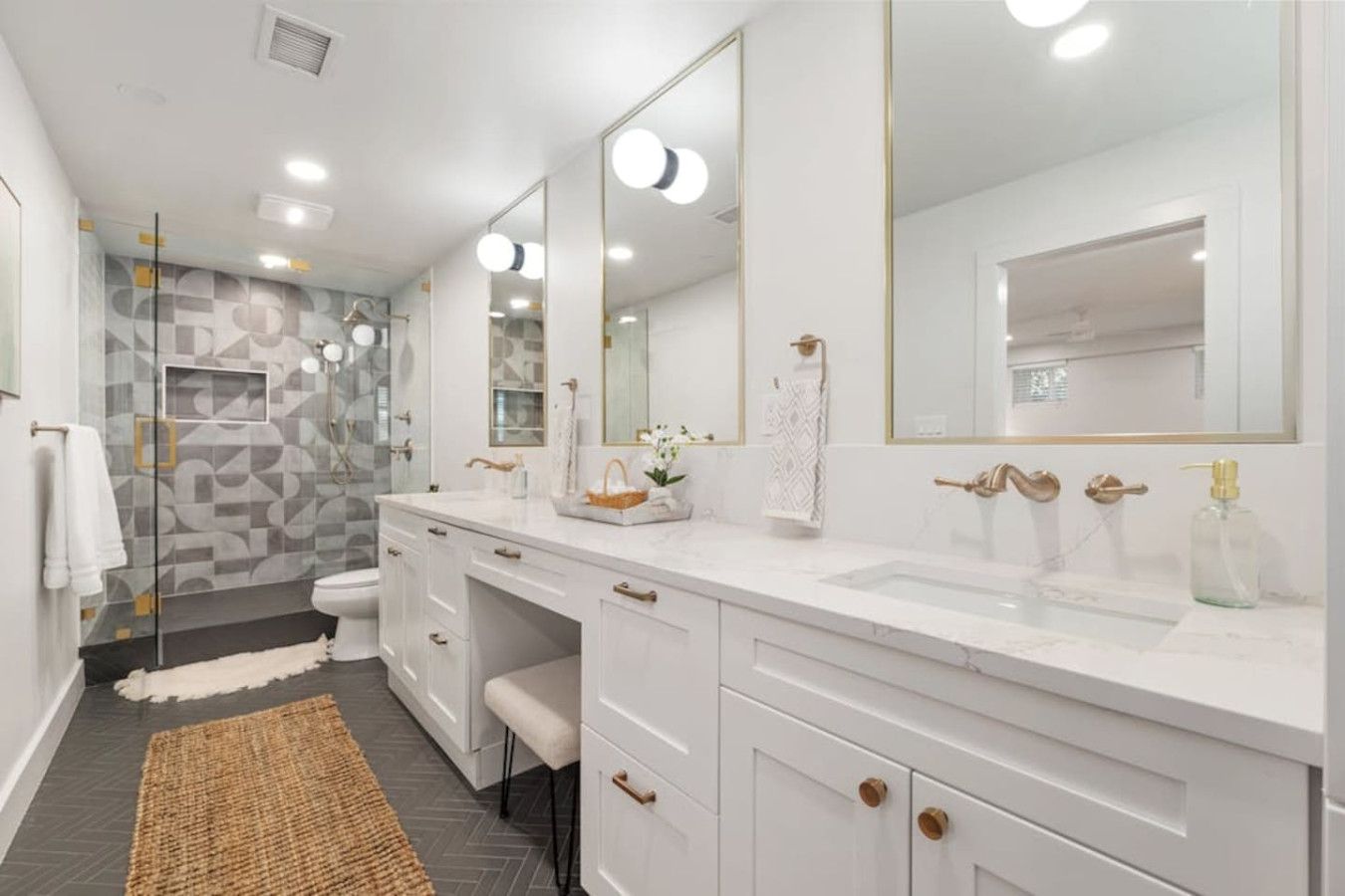 Un baño moderno con un espejo grande, dos lavamanos y una zona de ducha.