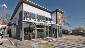 Un bâtiment moderne sur lequel on peut lire l’inscription : « Plaza Colombian Coffee ».