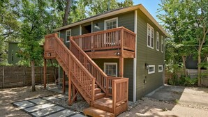 Une maison en bois à deux étages, avec un escalier en bois menant à un balcon.