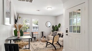 Un salon moderne comprenant un canapé, des fauteuils, une table basse et un coin repas avec une table et des chaises.