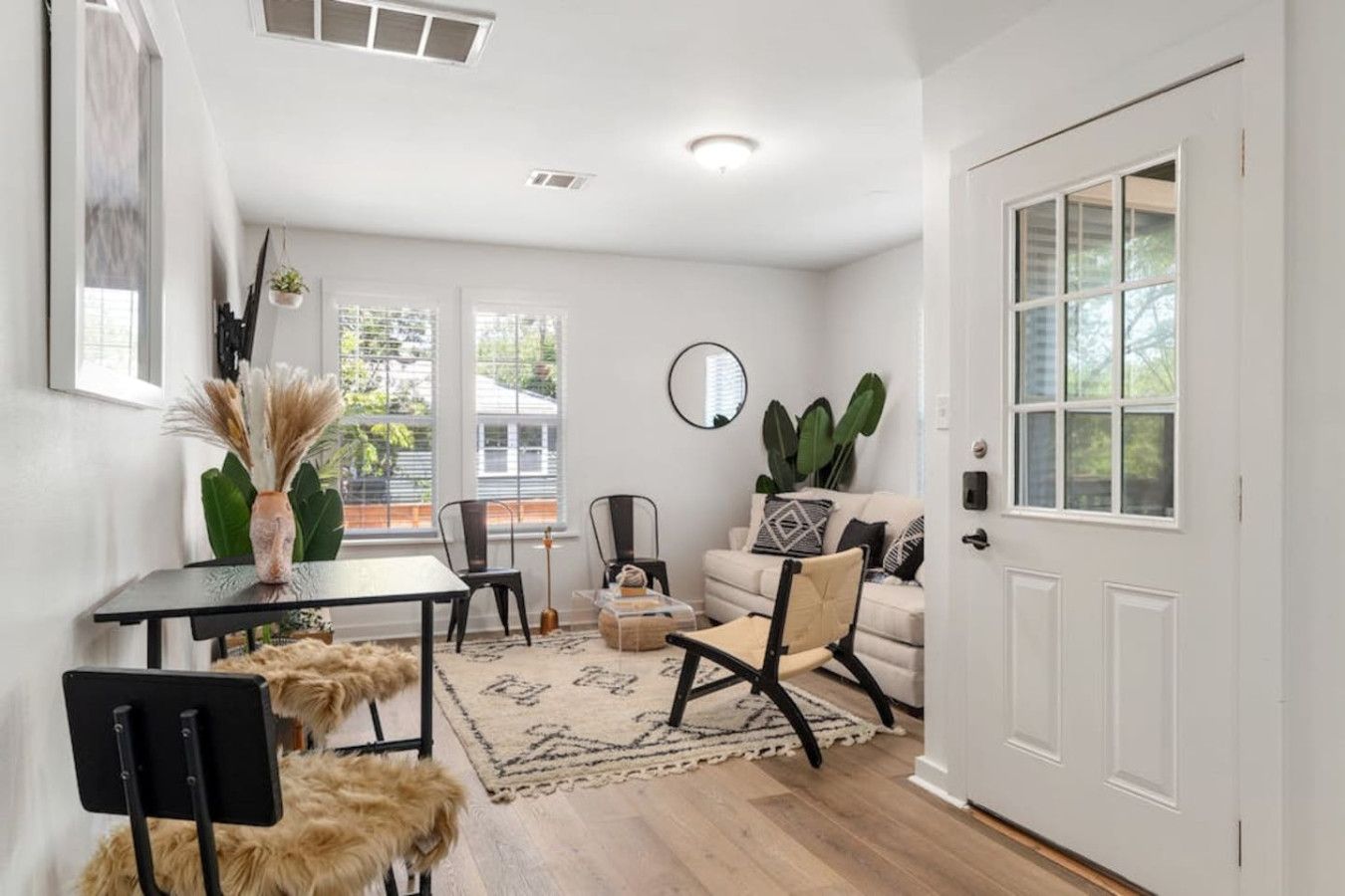 Un salon moderne comprenant un canapé, des fauteuils, une table basse et un coin repas avec une table et des chaises.