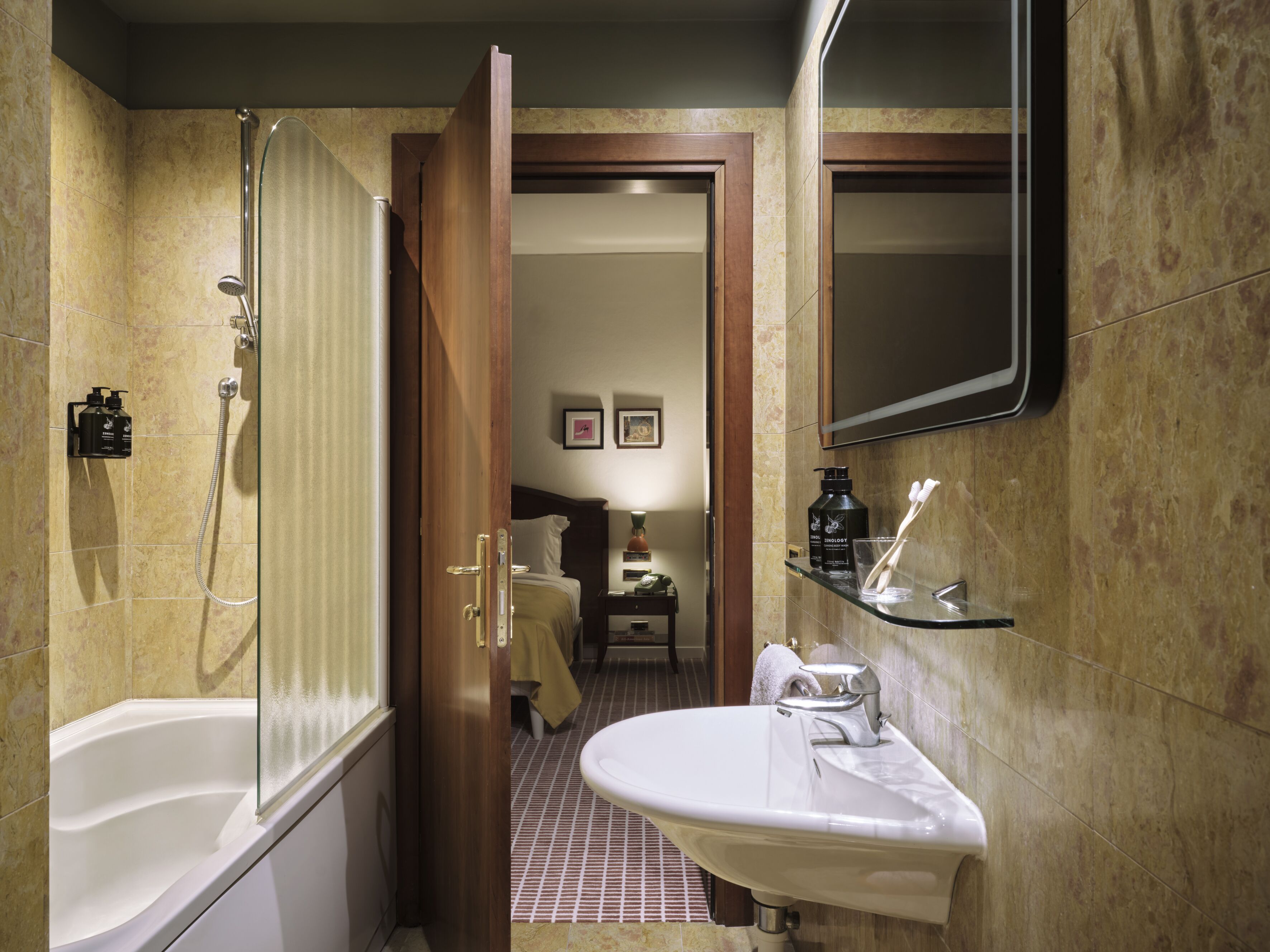 A bathroom with a bathtub, a shower, a sink, and a mirror.