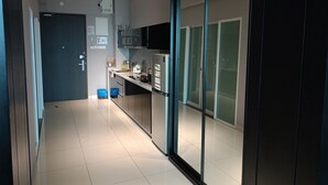 Een moderne keuken met een koelkast, magnetron en kastjes.