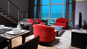 Een moderne woonkamer met een groot raam, een wenteltrap en een eethoek met een tafel gedekt voor twee personen.