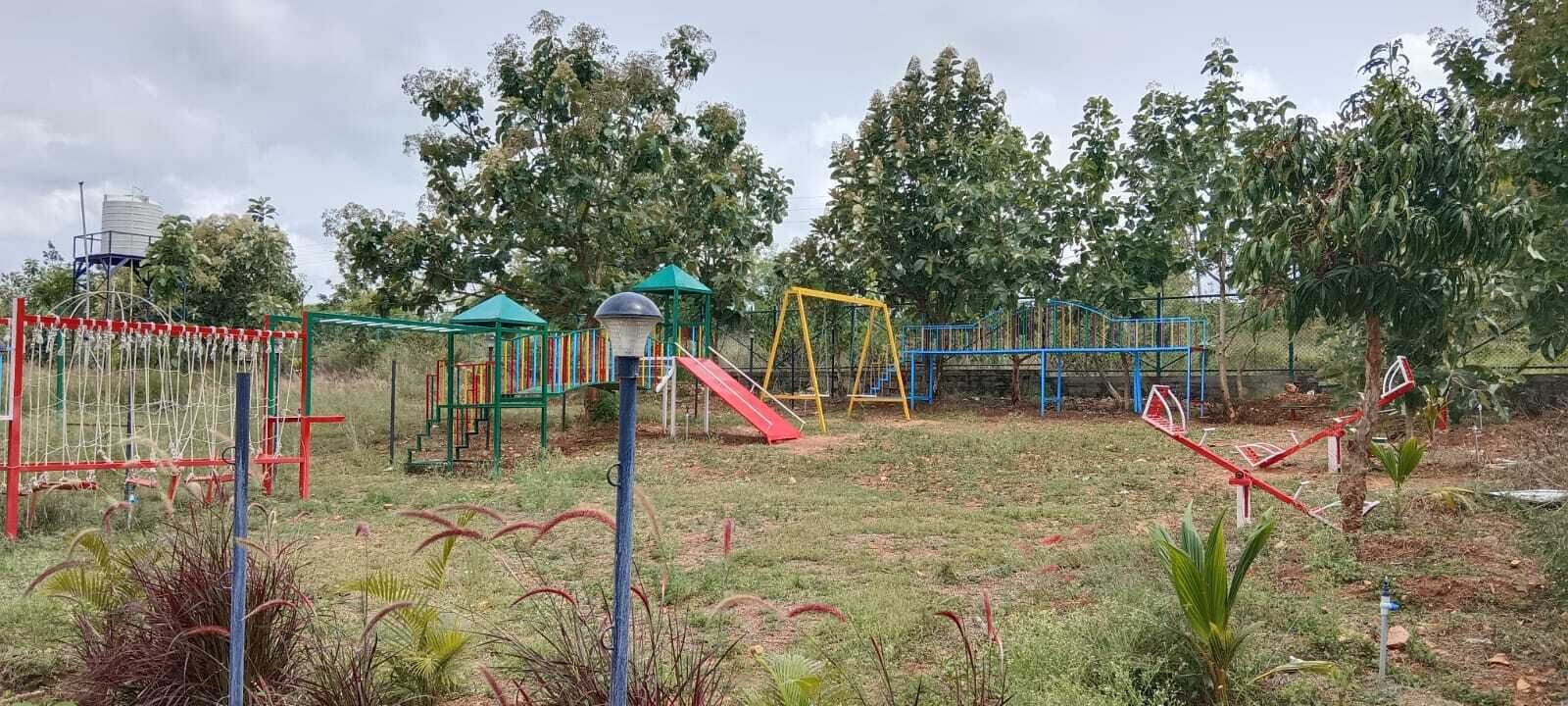 A playground with various play structures including a slide, swings, and climbing frames.